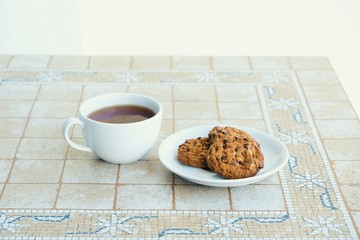 Cup of coffee and cookies on wooden table.