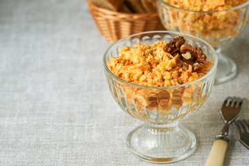 Rice salad with carrots, cheese and walnuts in a glass bowl