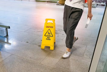 Yellow Caution wet floor sign on wet floor