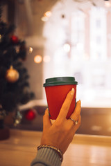 Cropped closeup photo of girl holding cup with black cap