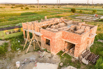 Aerial view of building site for future house, brick basement floor and stacks of brick for construction.