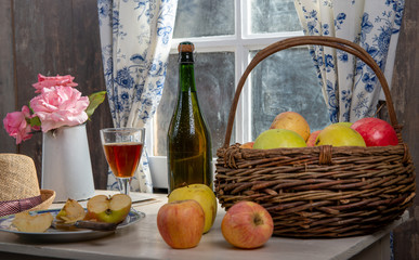 Obraz na płótnie Canvas Bottle and glass of cider with apples. In rustic house