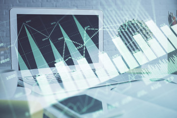 Forex graph hologram on table with computer background. Multi exposure. Concept of financial markets.