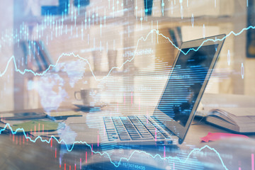 Forex market graph hologram and personal computer on background. Multi exposure. Concept of investment.