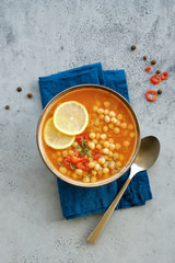 Chickpea lentil soup in bowl on gray background. Harira Moroccan soup. Comfortable food in the cold...