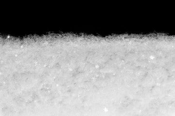 Snow on black background with snowfall. Snowdrift backdrop in winter season.