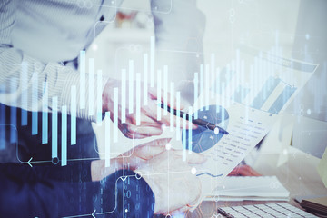 Financial trading graph double exposure with man desktop background.