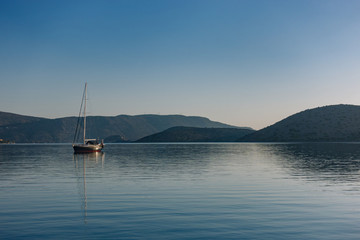Fototapeta premium Sailboat in the morning against the mountains.