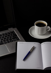 Office desk table with laptop, cup of coffee and other supplies. With copy space