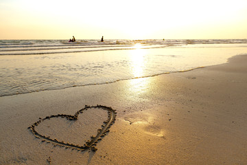 A beach with a heart written on sand
