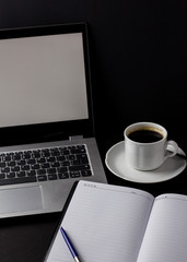 Office desk table with laptop, cup of coffee and other supplies. With copy space