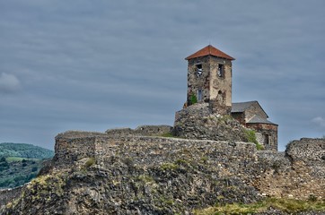 Fototapeta na wymiar une vieille chapelle sur une colline du Massif Central. Une chapelle et des fortifications. Une église et des remparts.