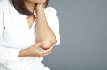 Naklejka premium Closeup woman hand holding elbow with pain lying on bed, health care and medical concept