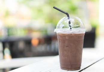 Close up glass of ice chocolate on wood table, selective focus