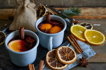 Mulled wine in gray metall mugs with orange and spices Rustic style