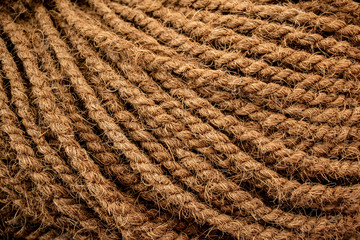 Thick coarse hand-knitted rope of coconut fiber. Natural background