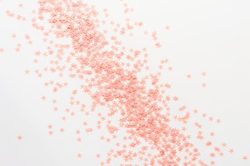 Pastel pink confetti stars on a white background. Holiday Party Concept