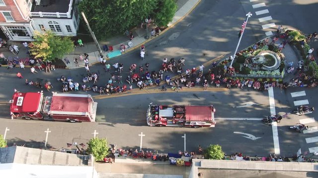 Firetrucks and motorcycles round the corner in Independence Day Parade in small town America