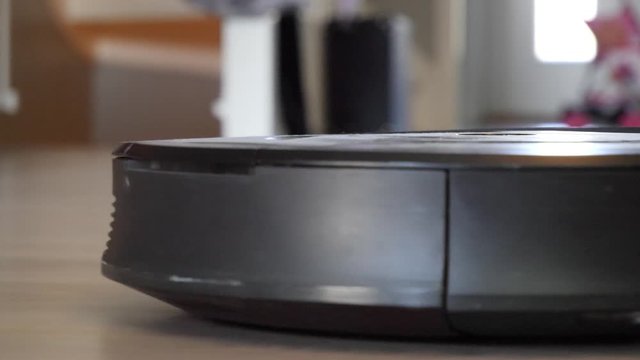 Autonomous robat vacuum sweeping the floor clean, - close up