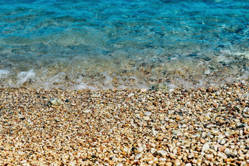 Beach, wet pebbles, seashore and waves-the sea beach and the concept of a beach holiday.