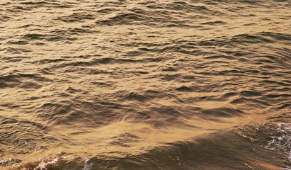 Background texture of a calm deep ocean with ripples on the surface of the sea water ,warm tone...