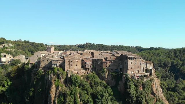 AERIAL TRUCK LEFT: Drone flying around the most amazing Italian medieval town standing on top of a mountain, Calcata Vecchia, the grooviest village in Italy