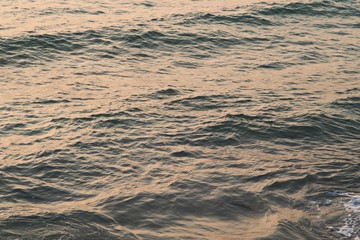 Background texture of a calm deep ocean with ripples on the surface of the sea water ,warm tone color  
