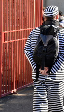 Un prisonnier sort de prison. Un homme en prison. Un p&eacute;nitencier. Un homme en costume de bagnard.
