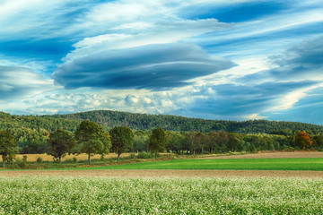 Lenticular cloud, a rare atmospheric phenomenon. Slezanski Landscape Park near Wroclaw, Poland. Sunny day in the mountains on the last days of September 2019.