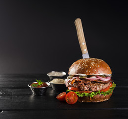 Tasty beef burger with knife ready to be served