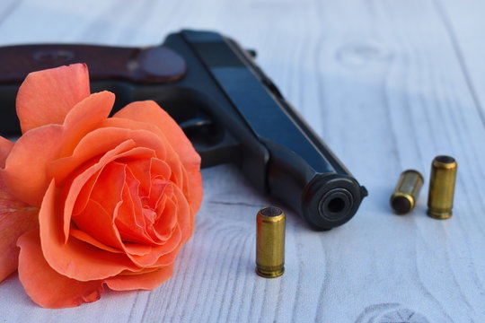 Love and hate. A gun with a red rose.