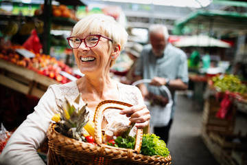 Mature woman buying vegetables at farmers market - Powered by Adobe