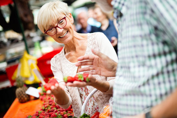 Only the best fruits and vegetables. Beautiful mature couple buying fresh food on market
