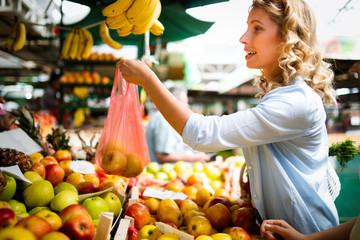 Picture of woman at marketplace buying vegetables