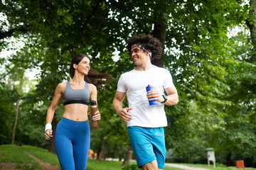 Happy young woman doing excercise outdoor in a park, jogging