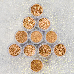 Christmas tree made of glitter in trendy turquoise green shades in small glass jars, top view selective focus