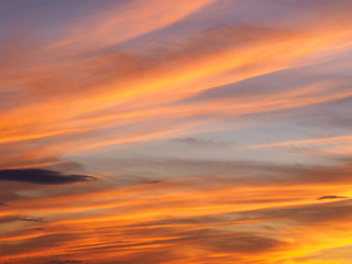 Clouds on a sky background illuminated by the sun's rays of the setting sun