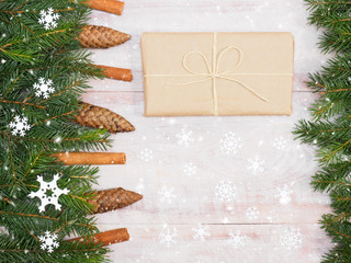 Fir tree branch with cinnamon, cones, snowflakes, presentl on wooden background. Christmas and New Year concept