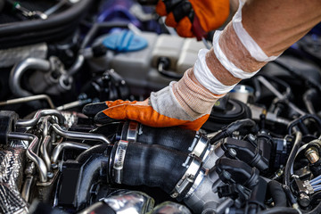 Automobile mechanic repairing a car engine. man fixing the engine car. service and maintenance.