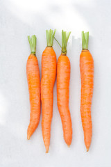 Raw fresh carrots on a light background.
