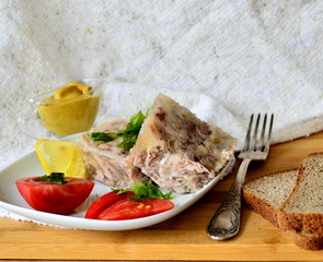 Jelly with meat, beef jelly, traditional Russian dish, serving on a plate, mustard, bread, tomatoes. Side light. Close-up.