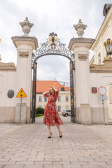 Obraz premium Cute cheerful caucasian woman walking on european street. She wear stylish outfit.