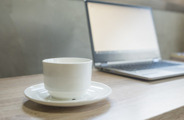 Laptop next to a cup of coffee