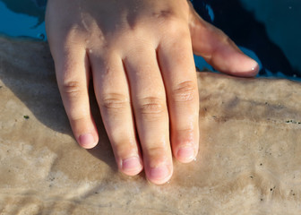 Hand of a boy in the pool