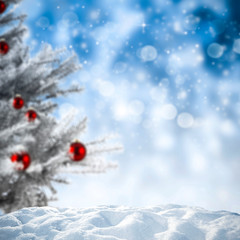 Christmas background of snow and xmas tree with blue blurred background 