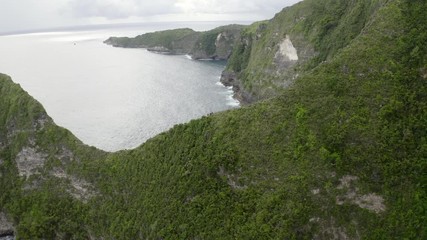 Aerial: Tourists hiking on mountain by sea - Nusa Penida, Bali