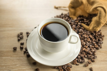 Coffee cup and beans on wood background
