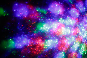 Abstract background with night lights. Festive backdrop. Creative colorful space. Defocused bright disco lights. Illuminated blurred pattern.