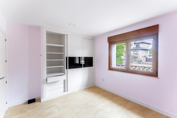 Colorful empty bedroom with green landscape in window. Interior modern bedroom with built-in wardrobes.
