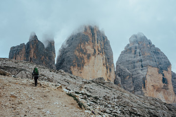 A person is hiking in front of the tre cime di lavaredo in the Dolomites, Italy